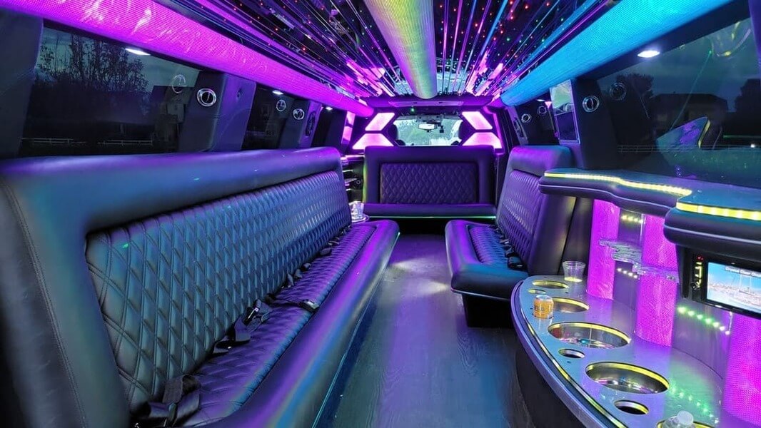 Interior of a luxury limousine with vibrant purple and blue ambient lighting
